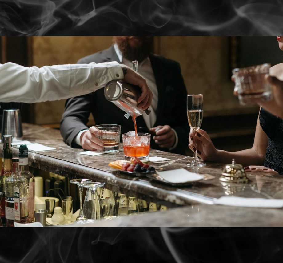 A professional bartender creating a masterpiece smoked cocktail.